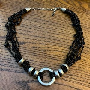 Multi strand black bead necklace with silver accents.